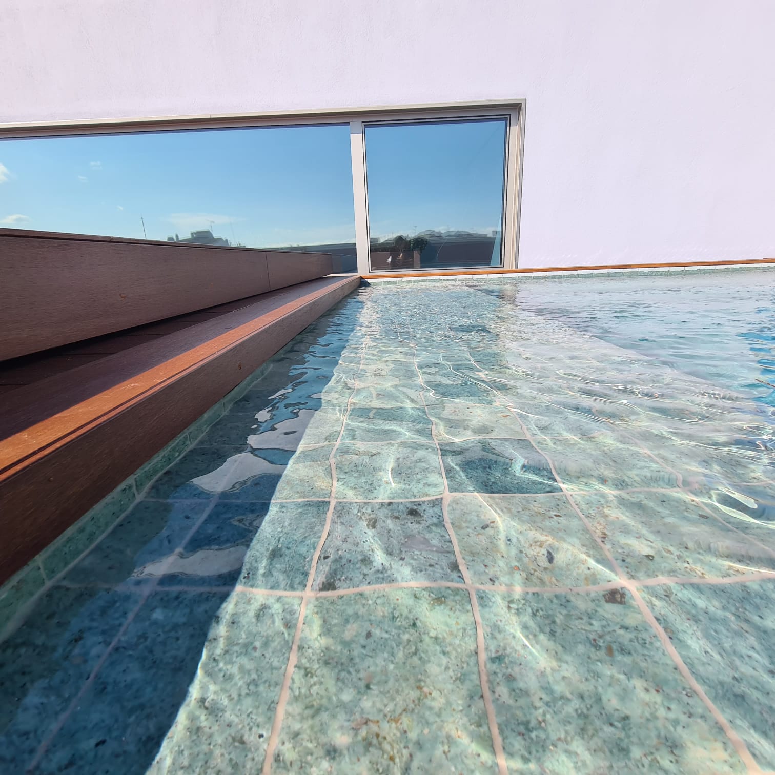 Piedra natural de Bali en piscina con reflejos turquesas y esmeralda
